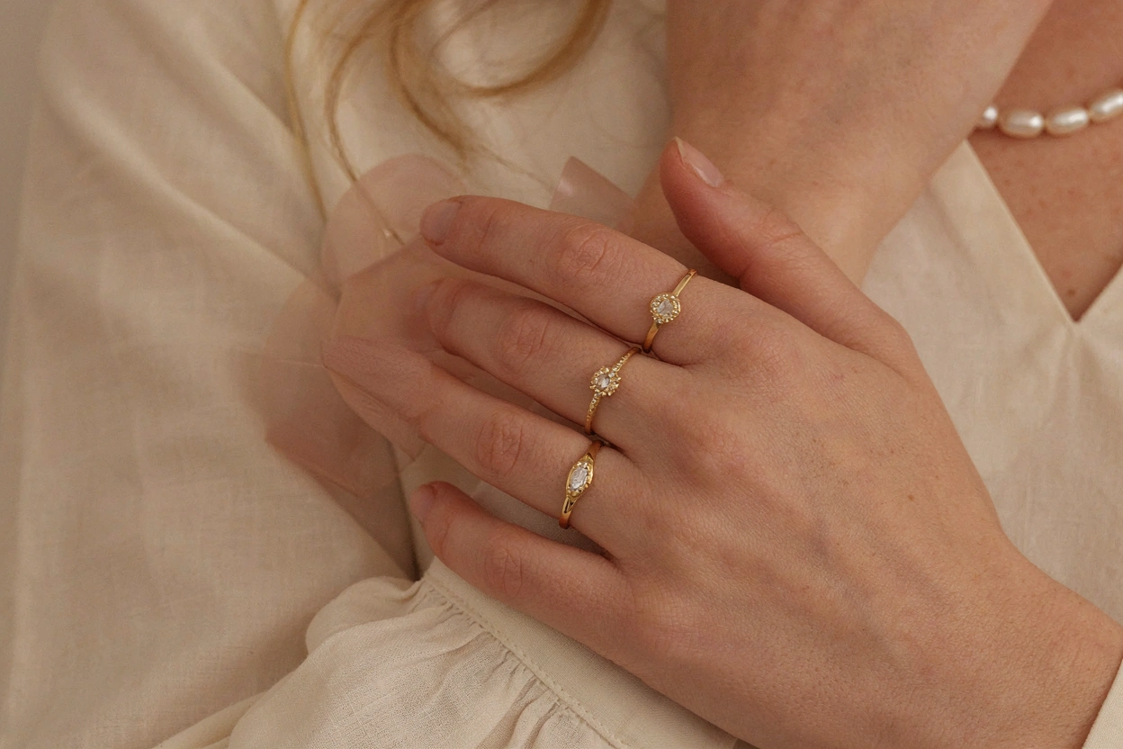 Mains ornées de bagues et d'un collier de perles